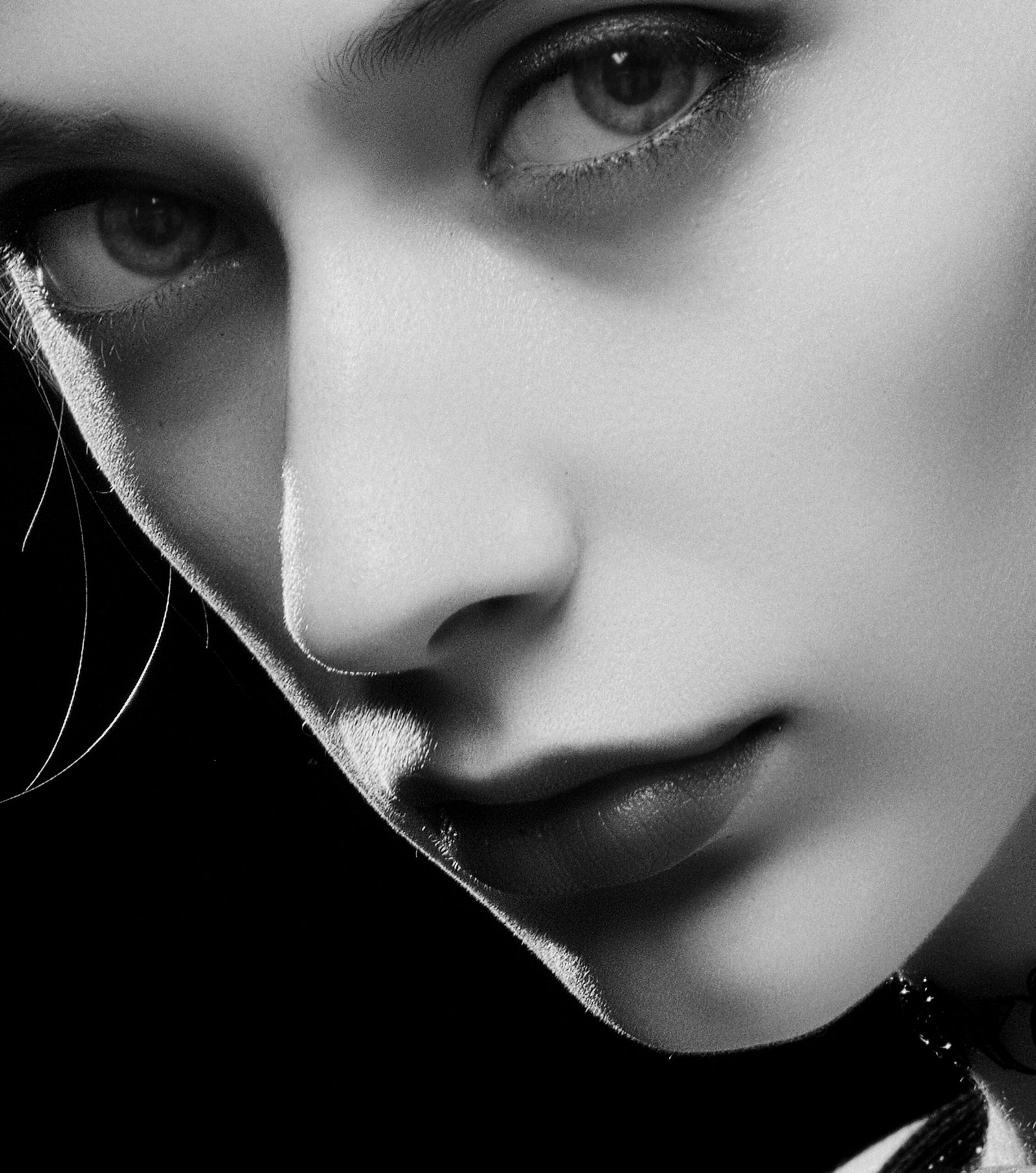 Black and white close-up portrait of a woman with expressive eyes and elegant features.