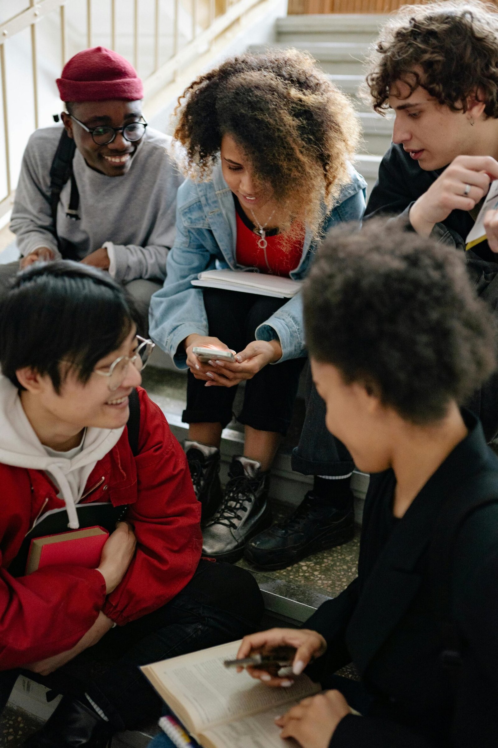 A diverse group of university students studying on stairs, promoting teamwork and education.